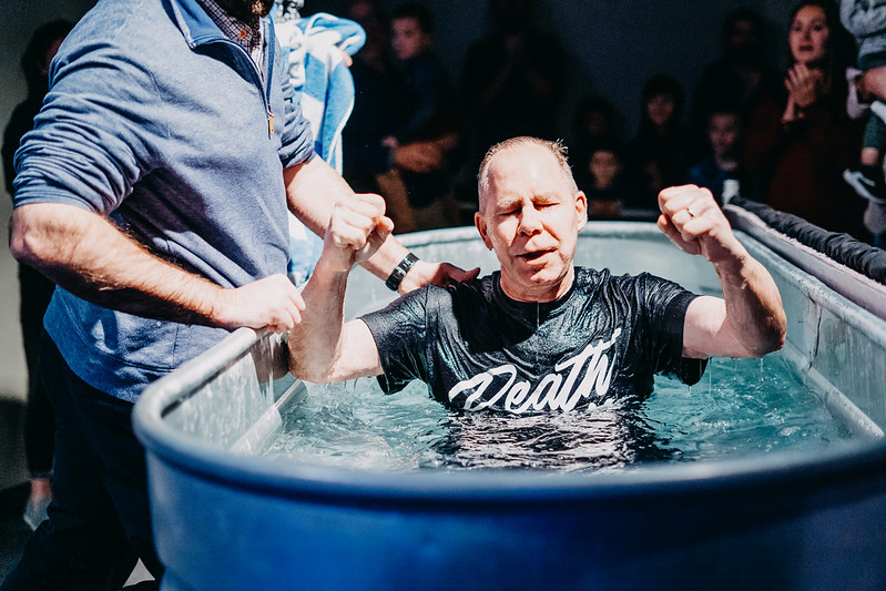 Man getting baptized at Mercy Hill Church, water tank, pastor